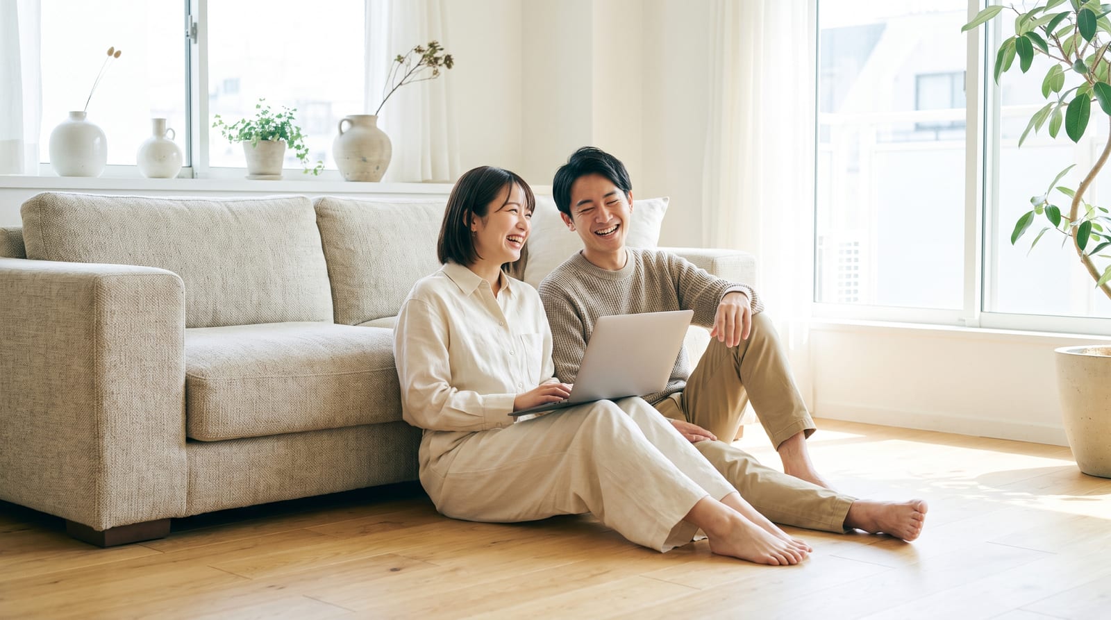 床に座ってノートPCを見ながら話しているふたり