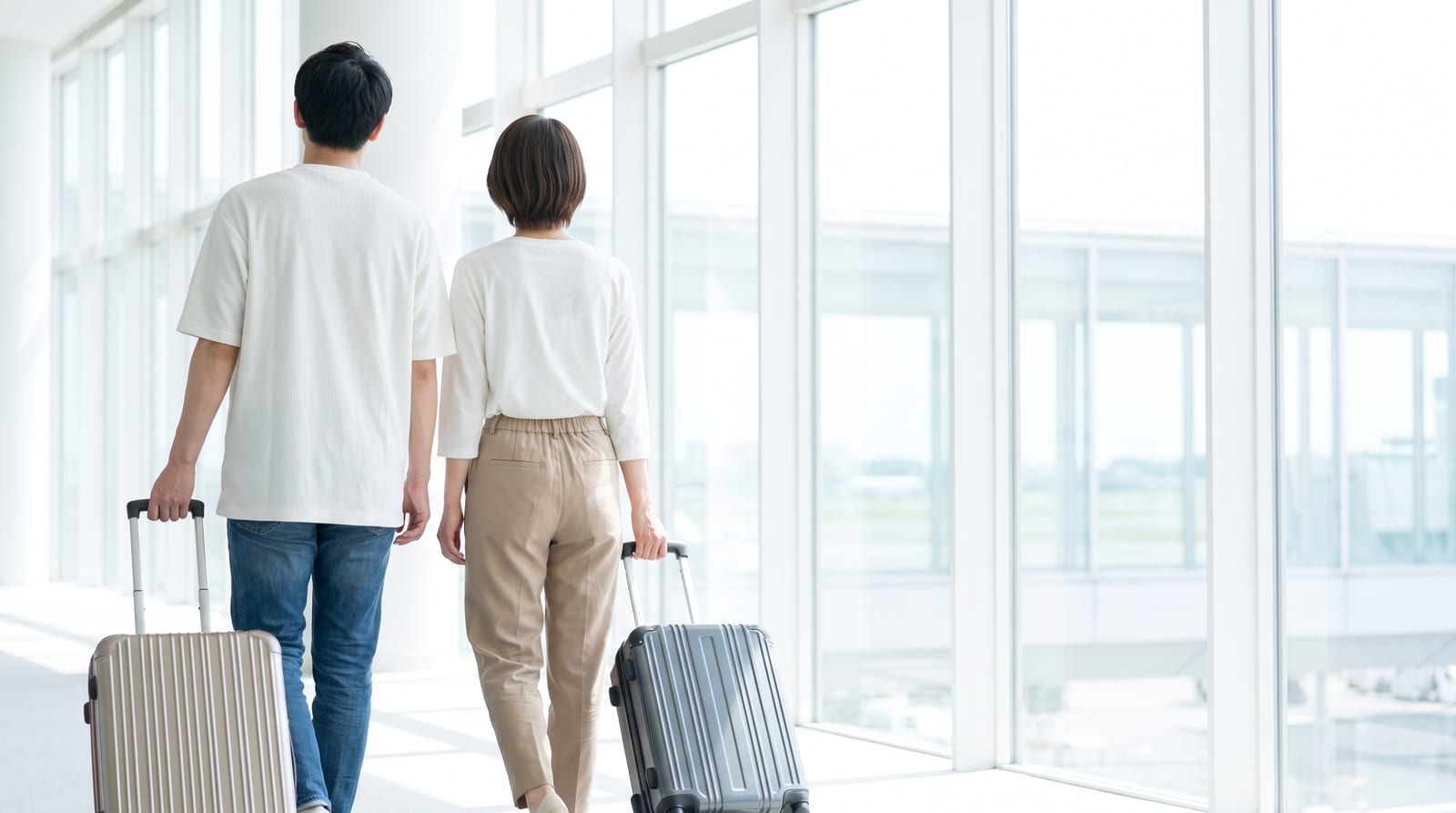 スーツケースを引いて空港を歩くふたり